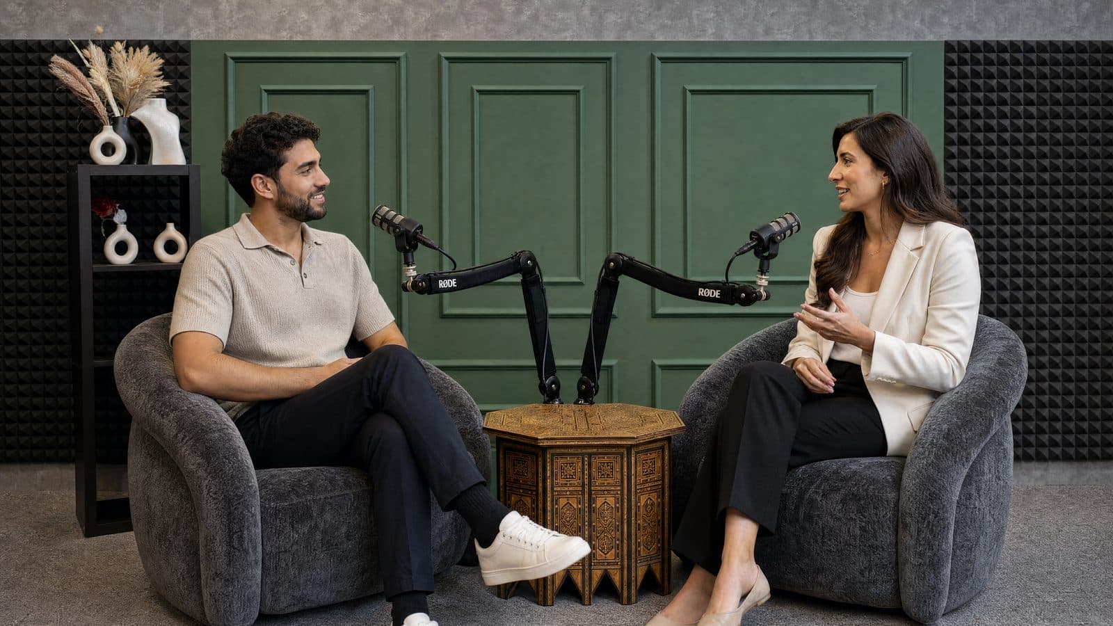 The Podcast Studio — two armchairs and microphones against a green panelled wall